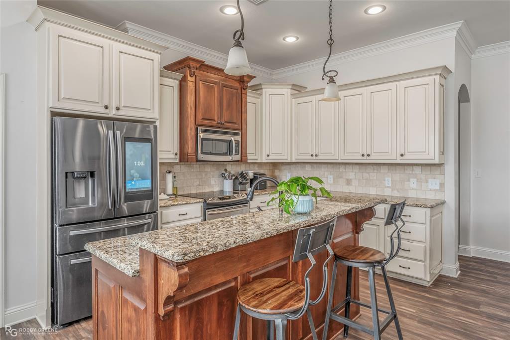 711 Reeds Reef Bossier City, LA 71112 - Photo 12 of 36 a kitchen with stainless steel appliances granite countertop a stove top oven a refrigerator a sink and chairs