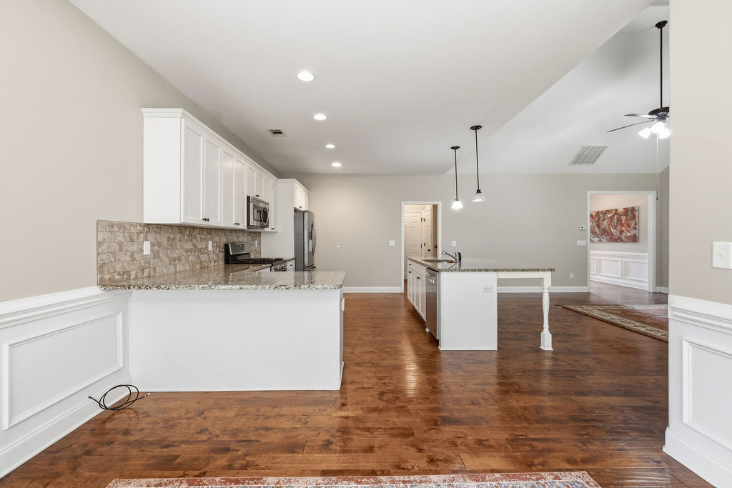 214 Friend Street Anderson, SC 29621 - Photo 12 of 40 This open concept kitchen features warm hardwood floors and a spacious island, perfect for gathering.