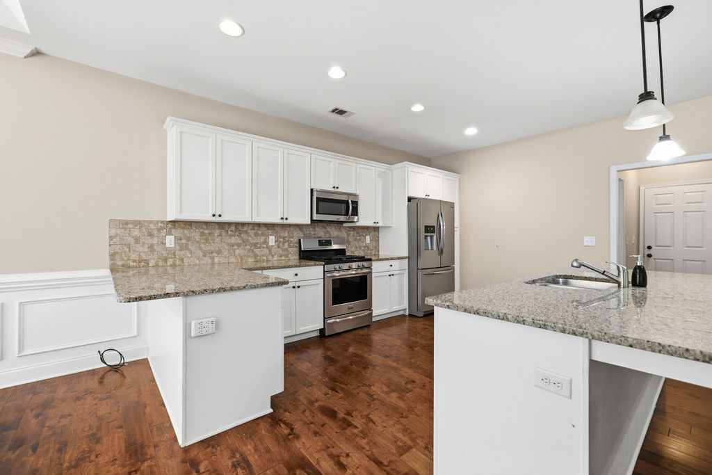 214 Friend Street Anderson, SC 29621 - Photo 13 of 40 This modern kitchen features rich hardwood flooring and stainless steel appliances.