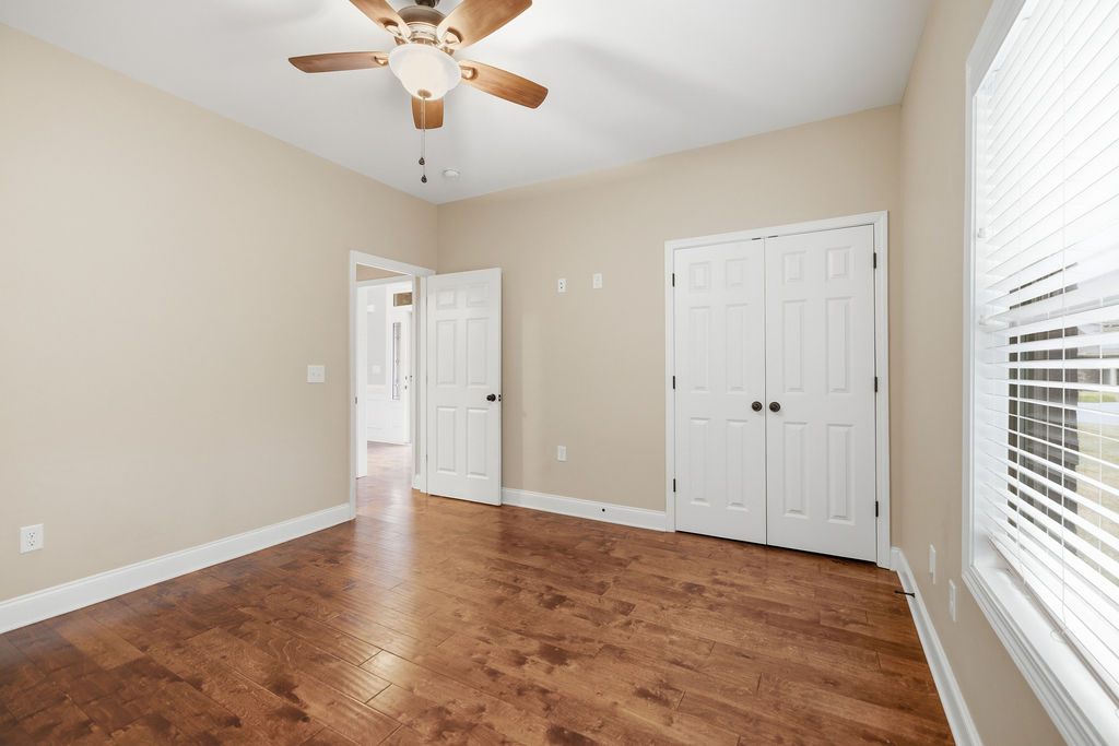 214 Friend Street Anderson, SC 29621 - Photo 23 of 40 This spacious bedroom features warm hardwood floors and abundant natural light through large windows.