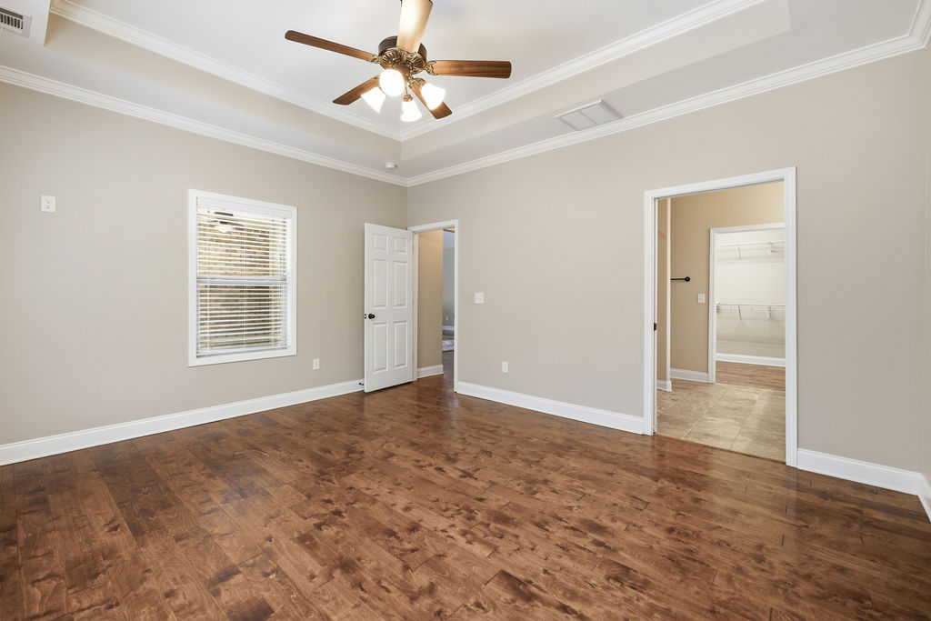 214 Friend Street Anderson, SC 29621 - Photo 26 of 40 This spacious bedroom features warm hardwood floors and a striking tray ceiling.