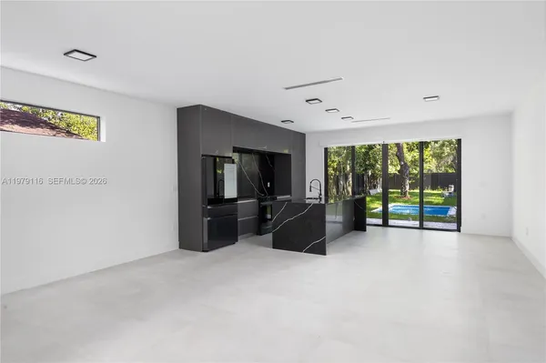 a view of a livingroom with furniture a flat screen tv and floor to ceiling window