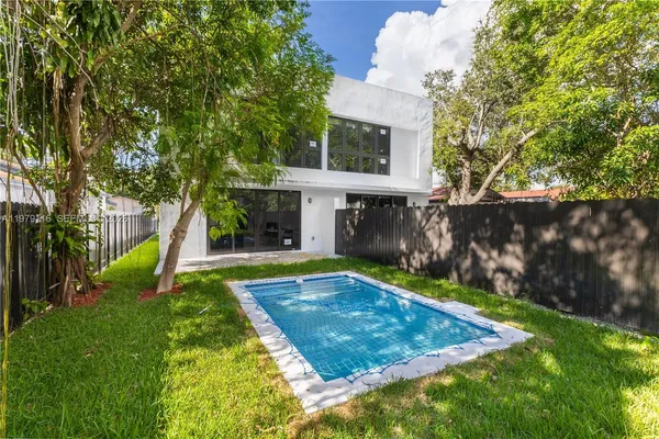 a view of a house with backyard and a tree