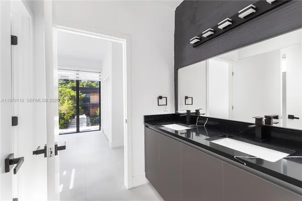 a bathroom with a granite countertop sink a toilet a mirror and shower