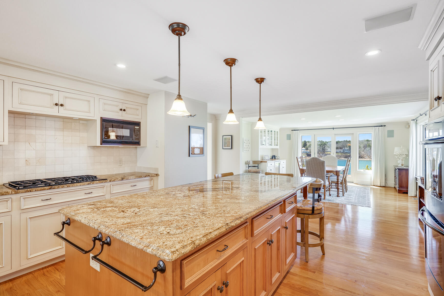 34 Jack Knife Point Road Orleans, MA 02653 - Photo 18 of 56 a kitchen with stainless steel appliances granite countertop a stove oven a dining table and chairs with wooden floor