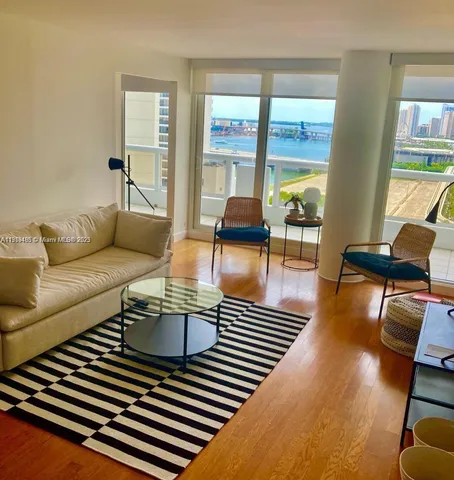 a living room with furniture and a floor to ceiling window