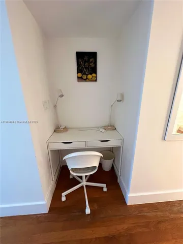 a view of a workspace with furniture and wooden floor