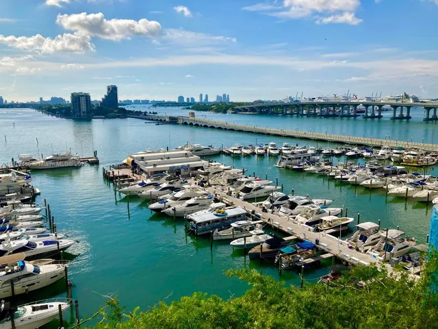 a view of a lake with boats and trees all around