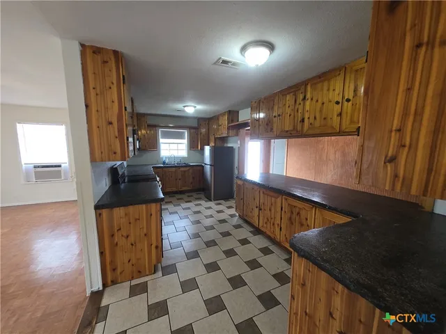 a kitchen with a sink a counter top space and cabinets