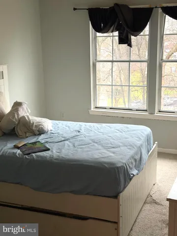 a bedroom with a bed and a large window