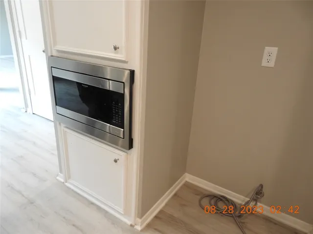 a view of kitchen with white cabinets and a sink