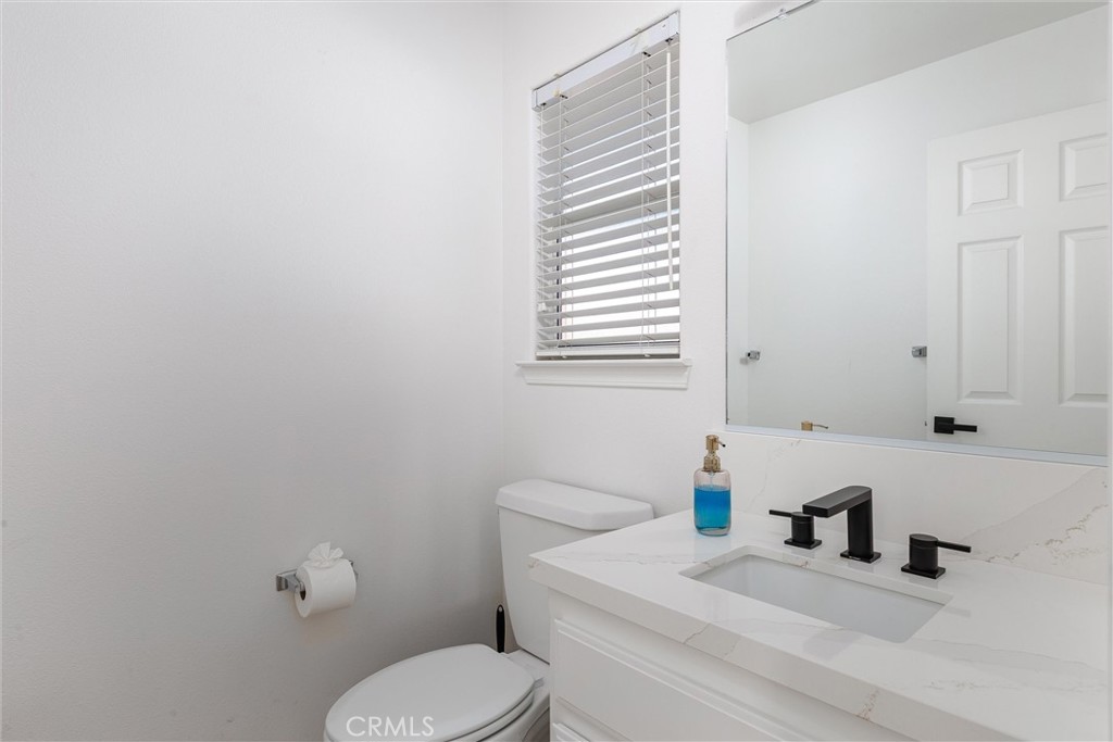 341 North 4th Street Grover Beach, CA 93433 - Photo 21 of 33 a bathroom with a granite countertop toilet sink and mirror