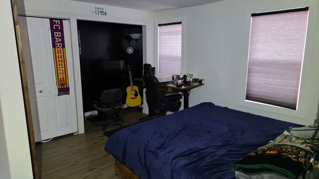 a bedroom with a bed and wooden floor