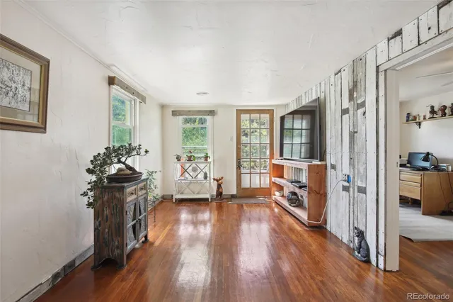 a view of a livingroom with wooden floor and furniture