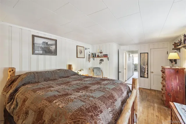 a spacious bedroom with a bed and wooden floor