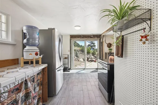 a open kitchen with stainless steel appliances granite countertop a refrigerator a stove and a wooden floors