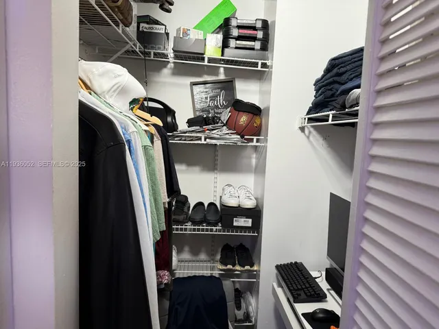 a view of walk in closet with clothes and shoes