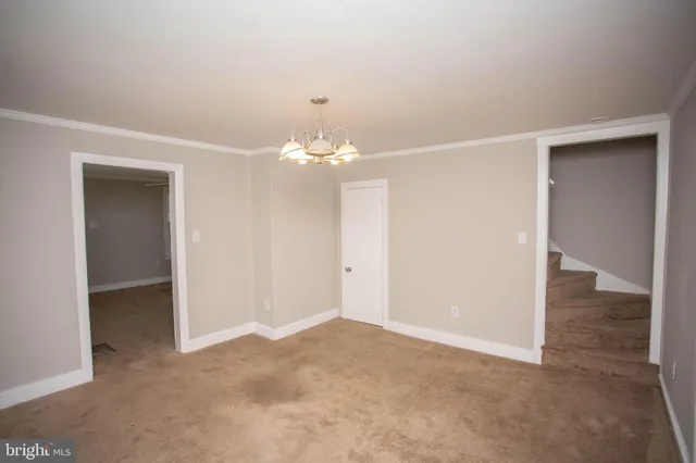 a view of a chandelier in big room and a bathroom