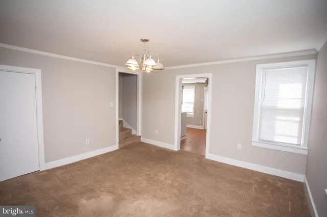 an empty room with chandelier and window