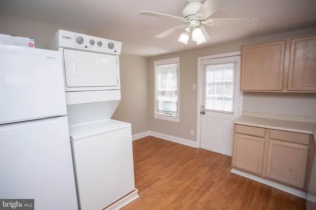 a kitchen with a refrigerator a sink and dishwasher with white cabinets