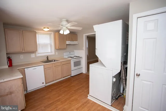 a kitchen with granite countertop white cabinets and white appliances
