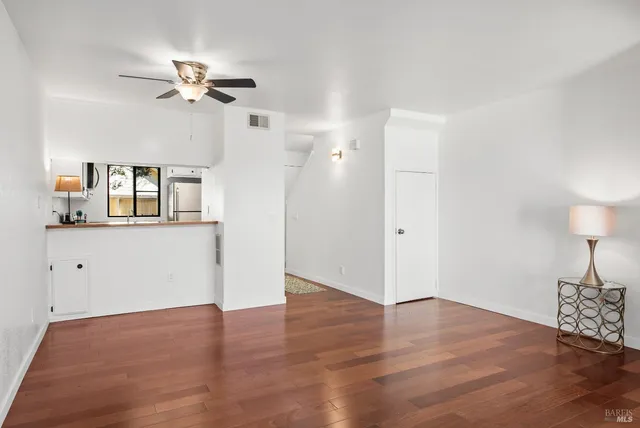 a view of a room with wooden floor and ceiling fan