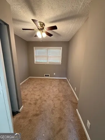 a view of room with window and ceiling fan