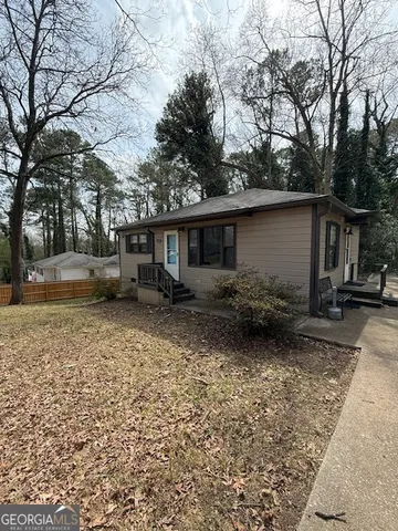 a backyard of a house with barbeque oven table and chairs