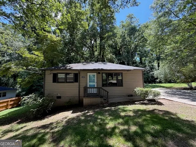 a backyard of a house with table and chairs under an umbrella