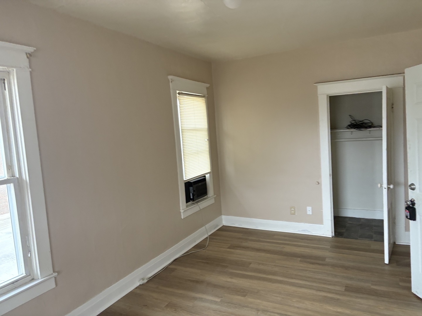 247 West Merchant Street Kankakee, IL 60901 - Photo 4 of 9 an empty room with wooden floor and windows