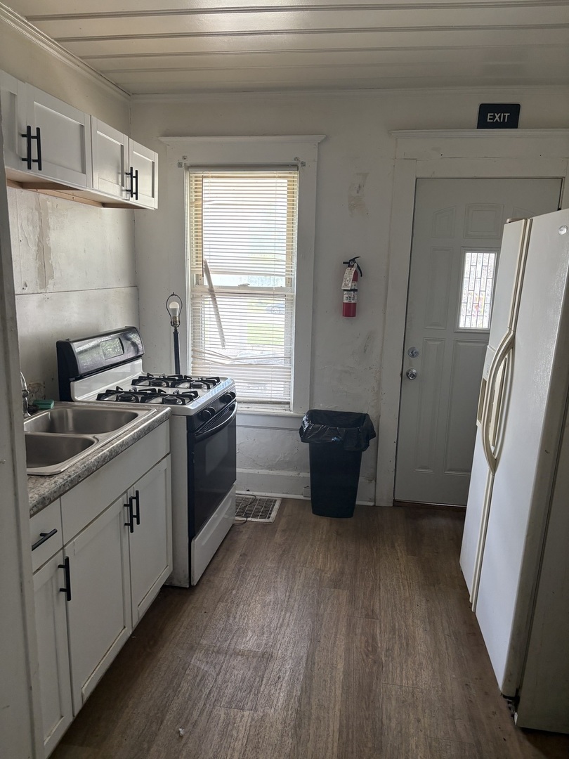 247 West Merchant Street Kankakee, IL 60901 - Photo 7 of 9 a kitchen with wooden floors and white stainless steel appliances