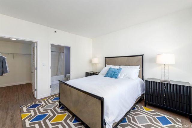 a bathroom with a granite countertop sink a toilet a large mirror and shower