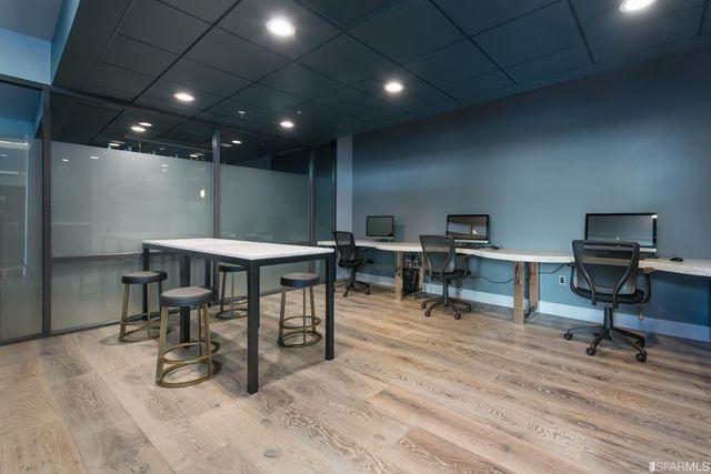 a group of people sitting under an umbrella in front of retail shop