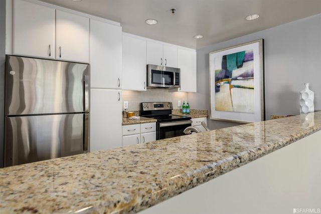 a kitchen with a sink refrigerator and microwave