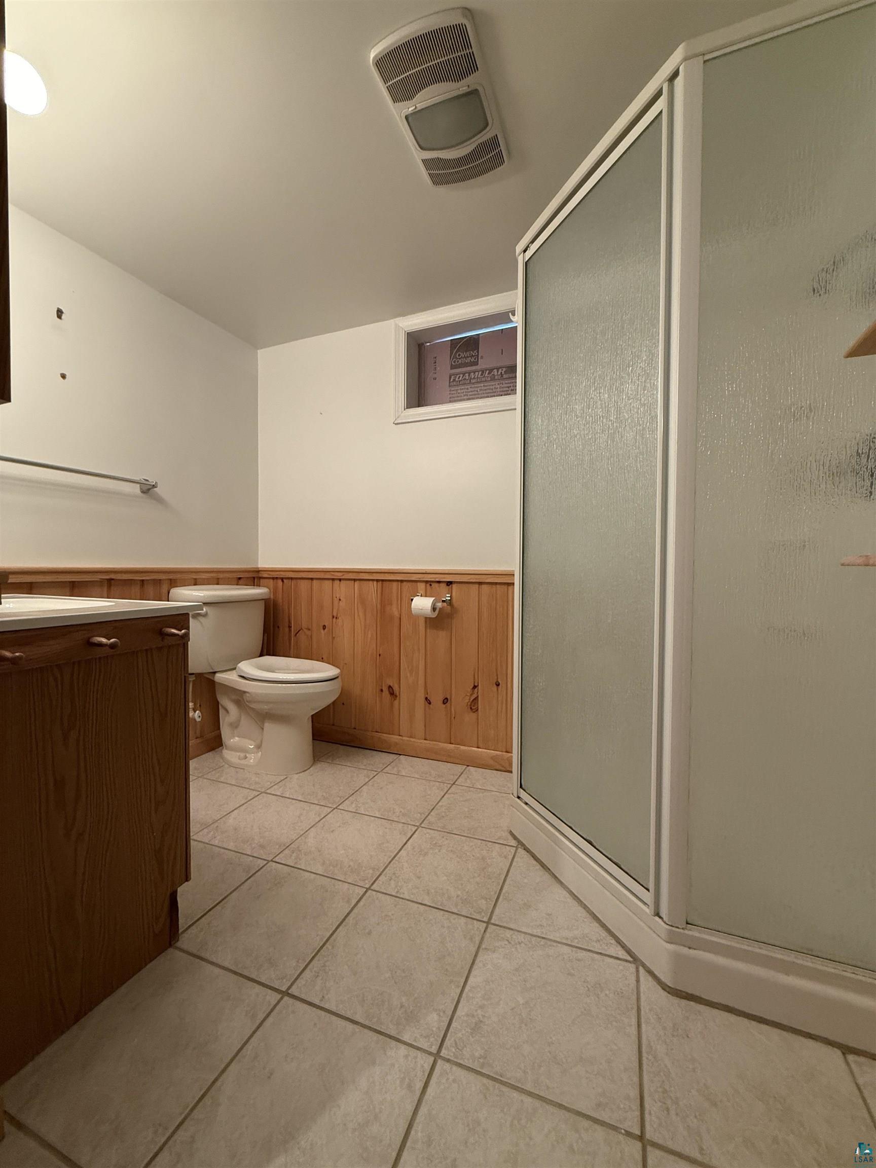 1321 South 13th Street Virginia, MN 55792 - Photo 26 of 33 Bathroom with wooden walls, vanity, a wainscoted wall, and a shower stall