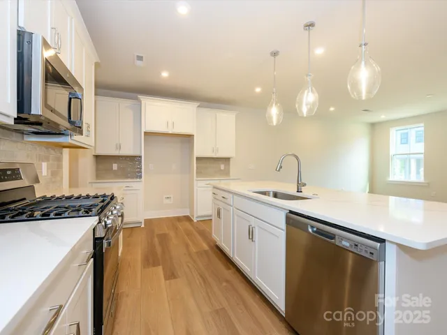 a kitchen with stainless steel appliances a sink stove and cabinets