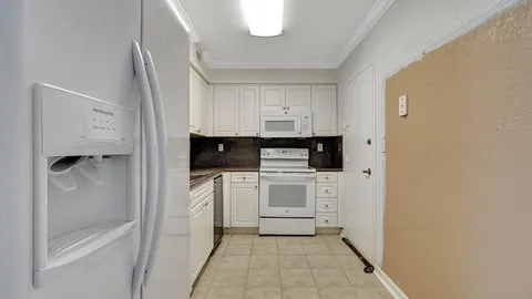 a kitchen with white cabinets and white appliances