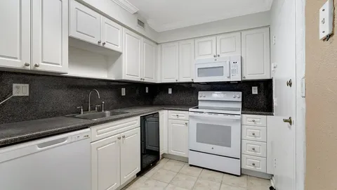 a kitchen with white cabinets and white appliances