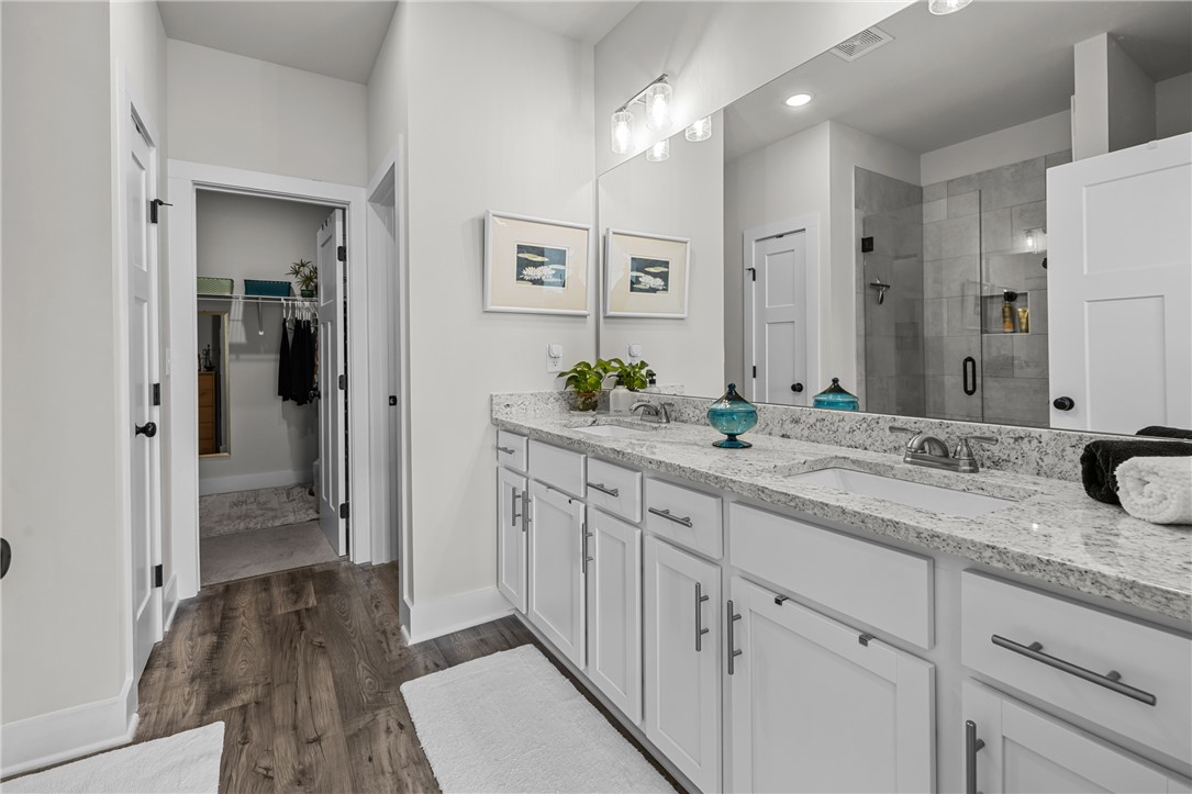 135 Bowers Estates Road Hartwell, GA 30643 - Photo 18 of 35 This spacious bathroom offers dual vanities and a walk-in shower for ultimate comfort.