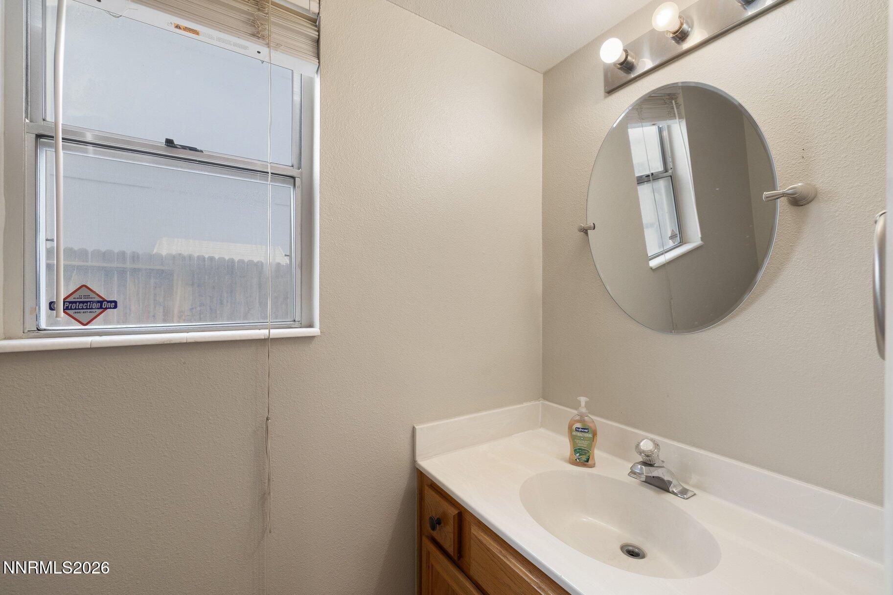 8486 Piper Place Reno, NV 89506 - Photo 20 of 80 a bathroom with a sink and mirror with toilet