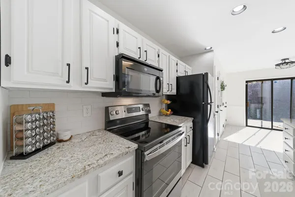 a kitchen with stainless steel appliances granite countertop a stove a refrigerator and a microwave
