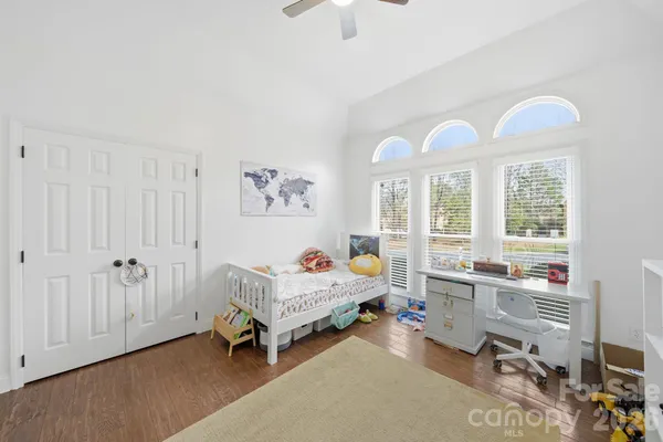 a living room with furniture two chandelier and a window