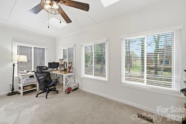 a view of a workspace with furniture and a window