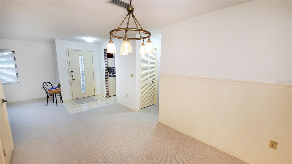 603 Baldwin Avenue, Unit B Safety Harbor, FL 34695 - Photo 5 of 32 en empty room with chandelier fan and refrigerator