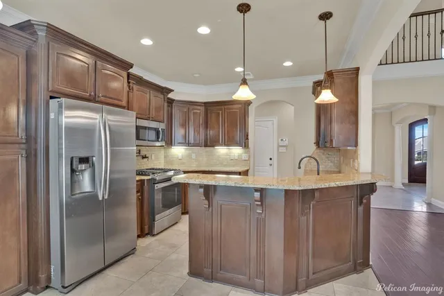 a kitchen with kitchen island a sink stainless steel appliances and cabinets