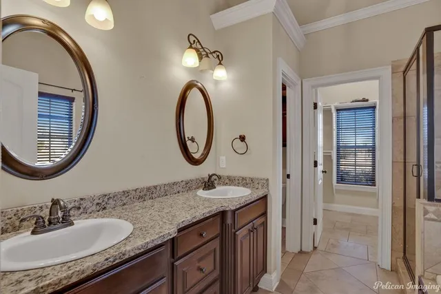 a bathroom with a granite countertop double vanity sink and a mirror