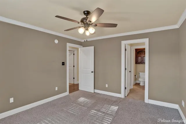 a view of an empty room with window and chandelier fan