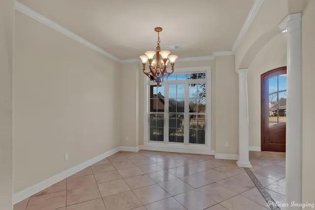 a view of a chandelier in an empty room with a window