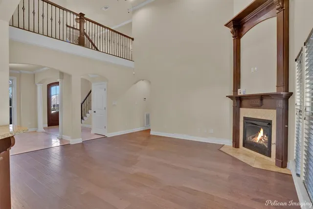 a view of an empty room with wooden floor and a fire place