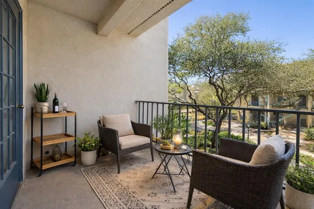 a balcony with wooden floor and outdoor seating
